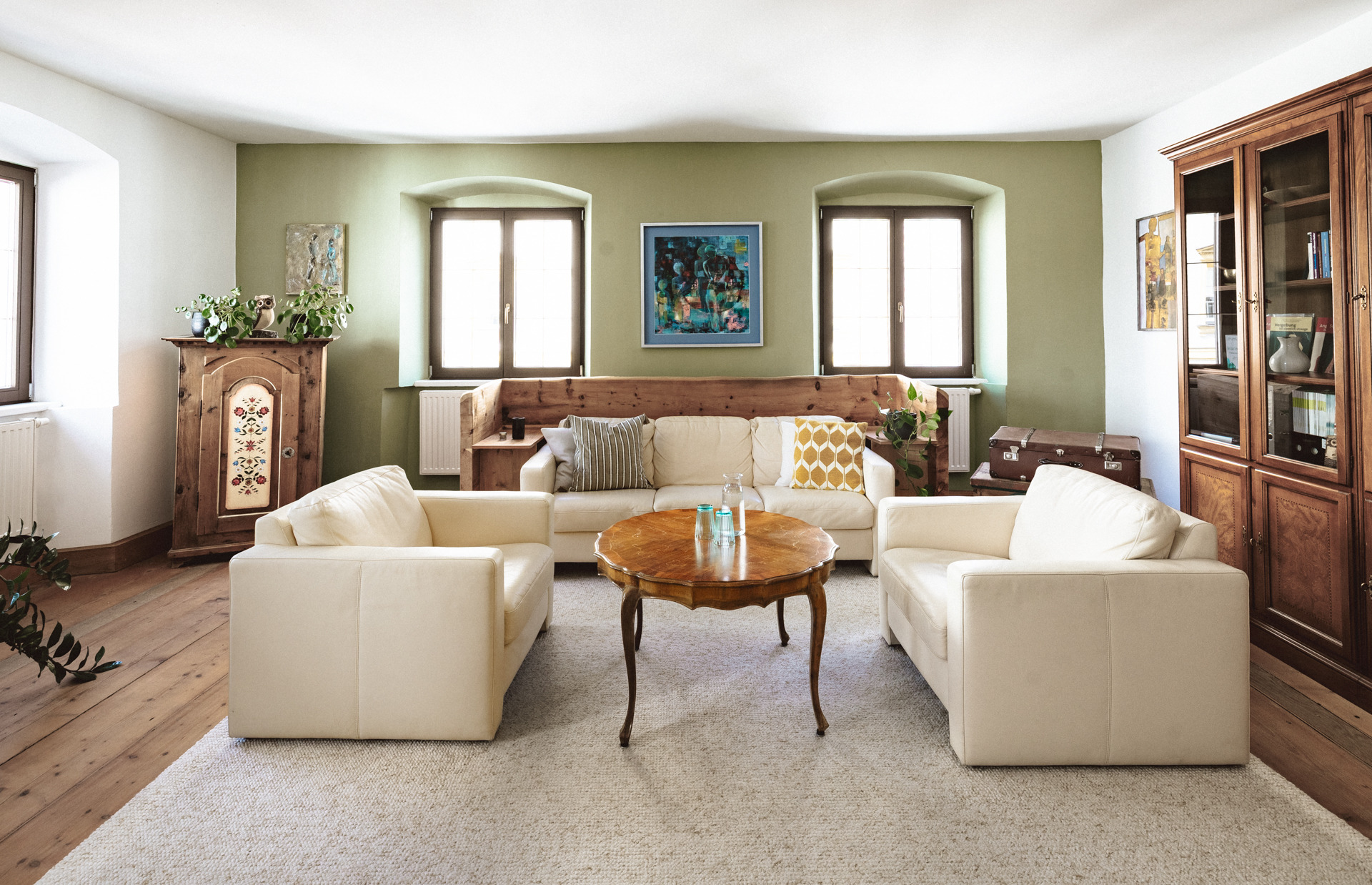 Praxisraum mit Sofa, Sesseln und großem Holztisch